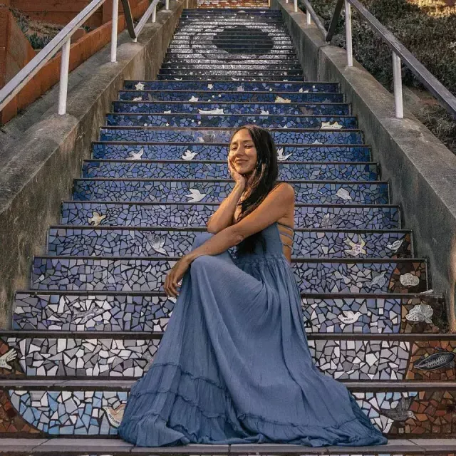 一名女子坐在贝博体彩app日落街区第16大道的瓷砖楼梯上.